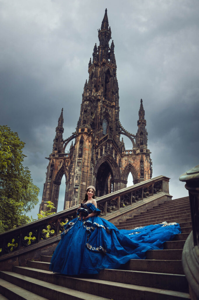 Quinceañera in a royal blue ball gown beneath the Scott Monument in Edinburgh