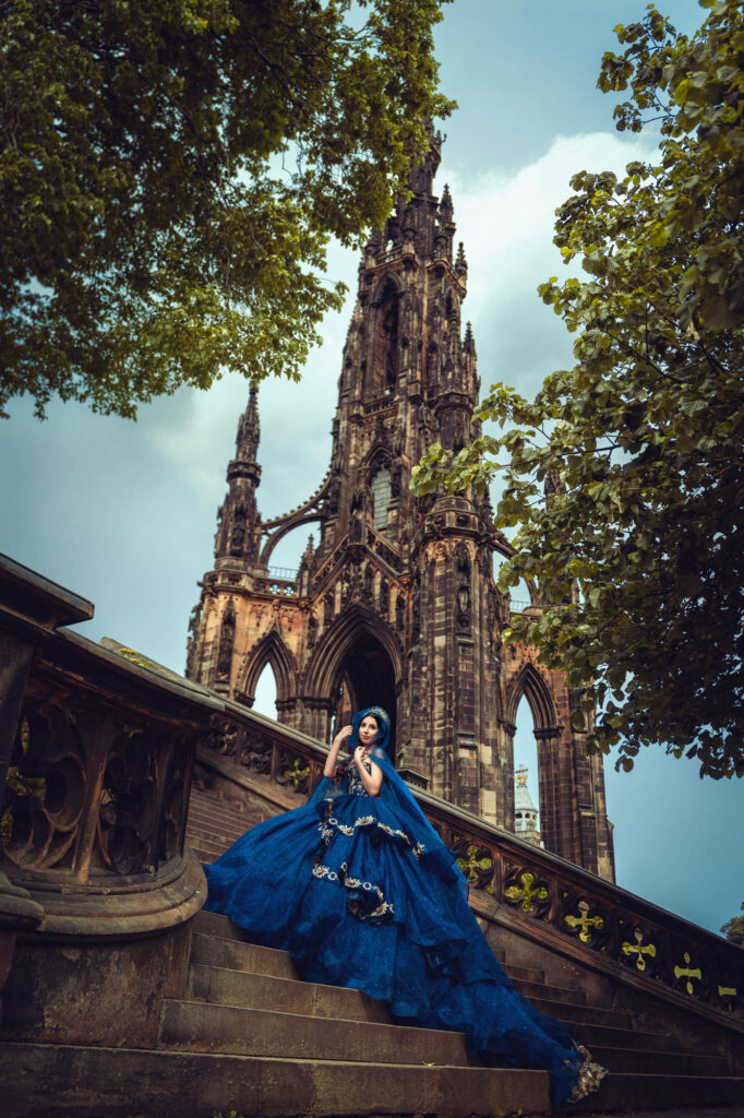 Quinceañera in a royal blue ball gown on the steps of the Scott Monument in Edinburgh, Scotland