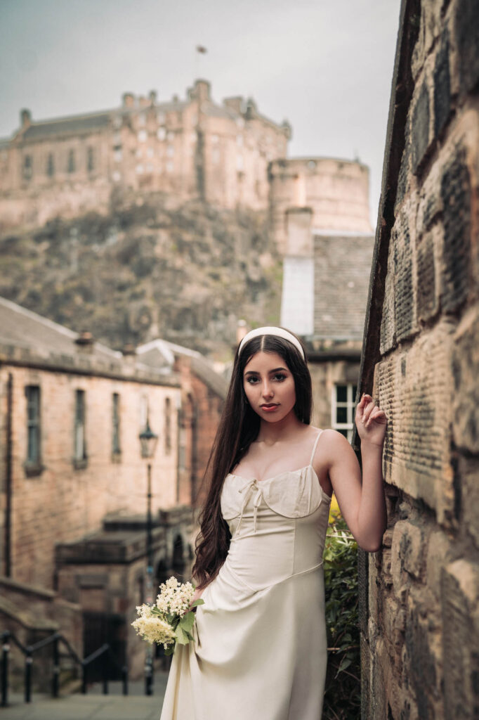 Quinceañera portrait in a white dress with Edinburgh Castle in the background