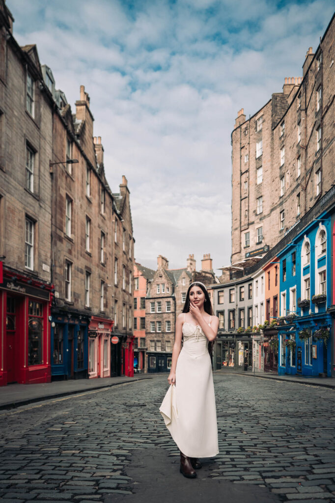 Quinceañera in a white dress on colorful Victoria Street in Edinburgh, Scotland